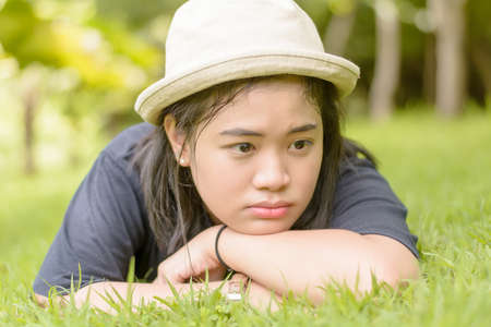 Young woman lying on grass in the park.の写真素材