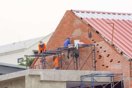 Construction worker is on steel scaffolding are repairing buildings.のeditorial素材