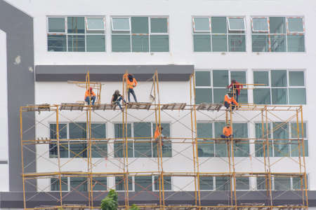 Construction worker is on steel scaffolding are repairing buildings.