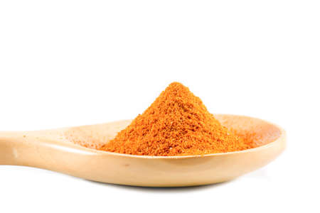 Cayenne pepper on the wooden spoon on a white background.