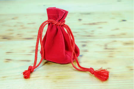 Red gift bag of The China New Year Festival on a wooden floor.の写真素材