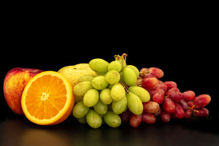 Orange, grapes, apple and pyrus pyriflora on a black background.の写真素材