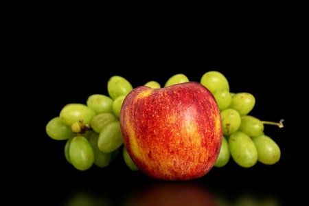 Grapes and apple on a black background.の写真素材