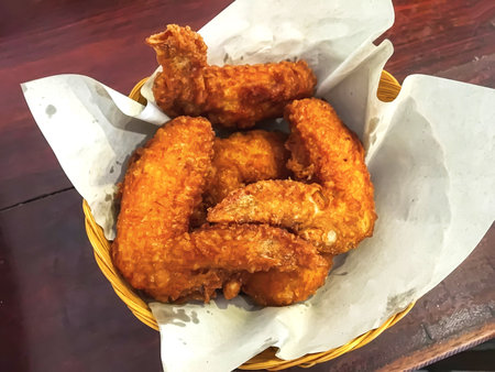 Fried chicken wings in a woven basket.の写真素材