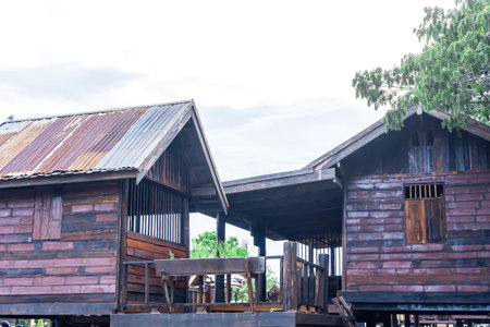 Two old wooden village houses connected by a covered wooden walkway, showing rustic textures and traditional craftsmanship.の写真素材