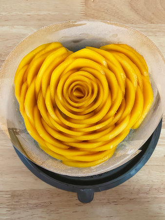 Beautiful mango sticky rice cake with ripe yellow mango slices arranged in rose flower shape.の写真素材