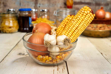 onions, garlic and corn in a glass bowlの写真素材