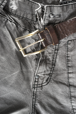 Leather brown belt on gray trousers の写真素材