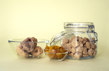 raisins, figs and brown sugar over yellow backgroundの写真素材