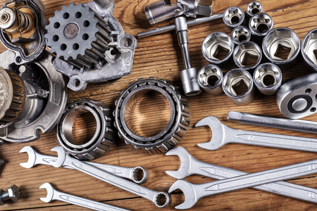 tools and old auto parts on wooden backgroundの写真素材