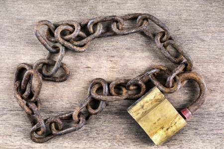 metal chain and locked padlock on wooden backgroundの写真素材