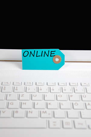 online written on paper tag on a keyboardの写真素材