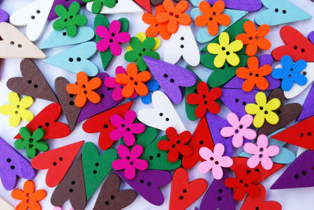many bright buttons in the shape of a flower and small multi-colored hearts