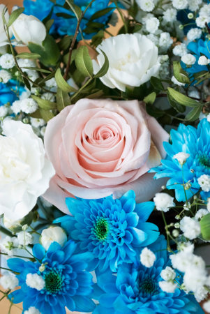 pink delicate rose in a bouquet with blue chrysanthemums and white carnationsの写真素材