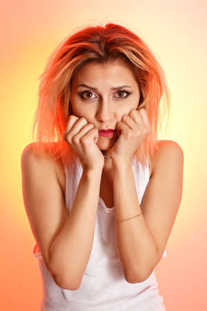 Girl in a white shirt on a pink-yellow background.