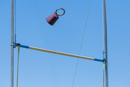 A close up shot of a kettlebell hanging on a pole in a sunny day