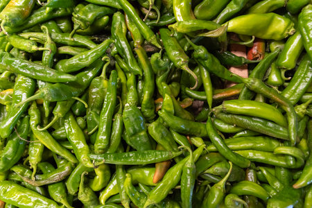 Green hot chili peppers on the market. Close-up image.の写真素材
