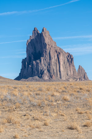 Shiprock in the four corners area of New Mexico on a sunny day with clear blue sky. The towering rock formation rises more than a thousand feet above the high desert plains.の写真素材