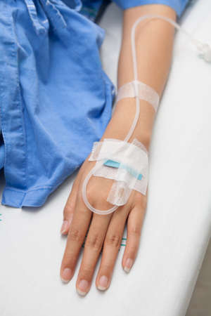 Close up of a hand woman patient in hospital with saline intravenous  iv の写真素材