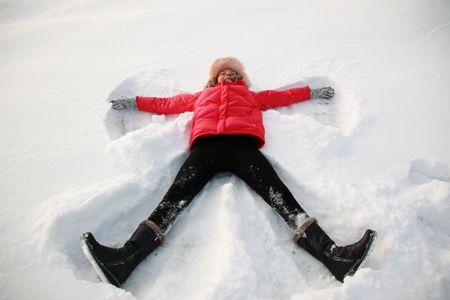 young girl playing with snow in parkの写真素材