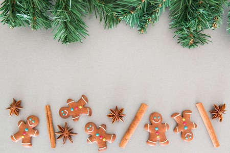 Christmas fir tree and gingerbread cookies on grey board
