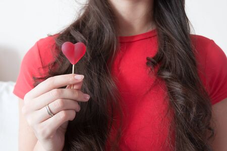 Girl with red heart shape candy in Valentine's Dayの写真素材
