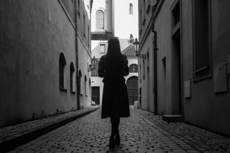 Modern young woman in old europian city in black and white colorsの写真素材
