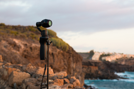 TENERIFE, SPAIN - 13.02.2017: Camera DJI OSMO plus in sunset at the seaside. Innovative digital camera is a new generation with electronic stabilizerのeditorial素材