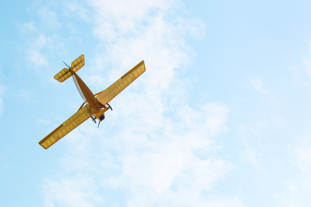 Vintage yellow airplane in blue sky, sky background