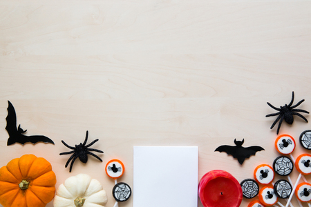 Halloween holiday background with spiders, bats, candies and pumpkins on woodの写真素材