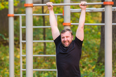 Man on horizontal bar in autumn park