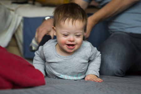Cute baby boy with Down syndrome playing with dadの写真素材