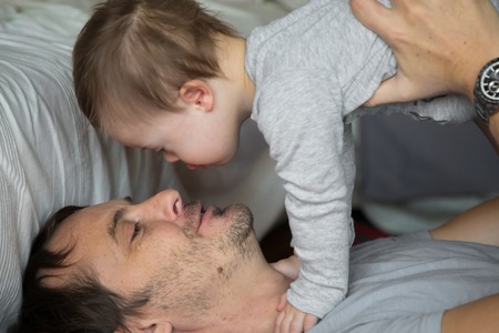 Cute baby boy with Down syndrome playing with dad