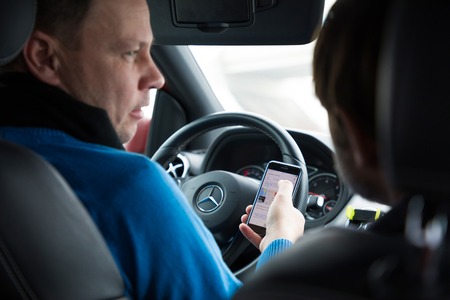 Prague, Czech Republic - 21.01.1018: Man using smart phone in car during drivingのeditorial素材