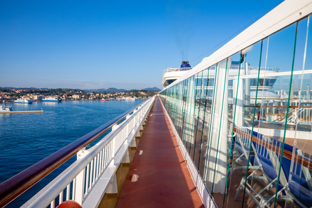Perspective view of outdoor steel deck at a cruise ship with sea and town in the background, Greeceのeditorial素材