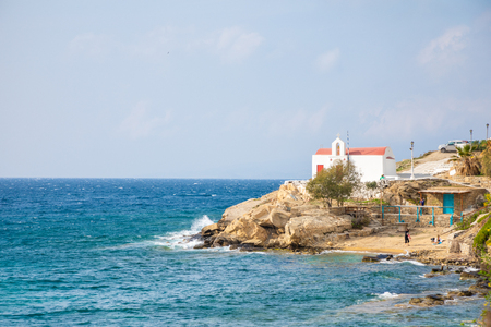 Typical Greek church white building with red dome against the blue sky on the island Mykonos in Greeceの写真素材