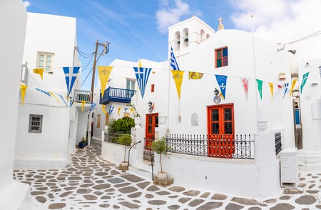 Mykonos, Greece - 17.10.2018: Traditional houses with blue doors and windows in the narrow streets of greek village in Mykonos in Greeceのeditorial素材