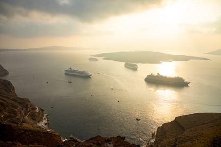 Amazing evening view from Fira on cruise ships at sunset, Santorini in Greece