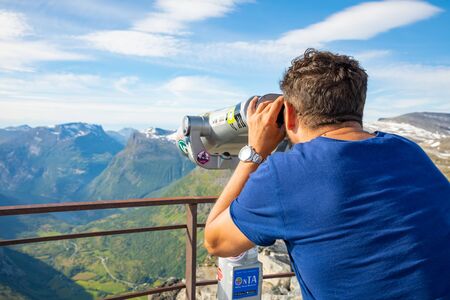 Dalsnibba, Norway - 26.06.2018: Man looking in Binoculars on view point Dalsnibba, view of Gejranger fjord in Norwayのeditorial素材