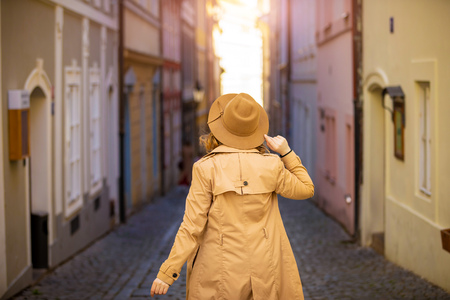 Girl in a beige hat and coat in narrow street of Prague city in Czech Republicの写真素材