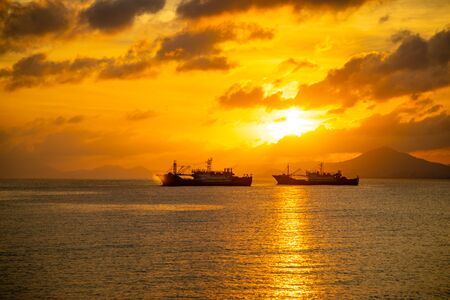Fishing boats on sea in sunset lights in Sanya, Hainan in Chinaの写真素材