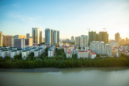 Sanya, Hainan, China - 04.07.2019: Aerial view of Sanya city with river at sunset light in Hainan...