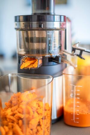 Close up of carrot pulp from process preparation of fresh juice in juicer in home kitchenの写真素材