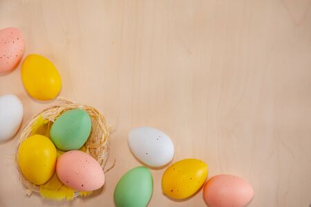 Colorful easter eggs on wooden background with text copy space