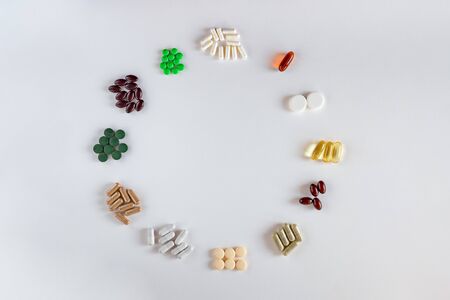 Medication with different types and colours as clock face isolated on white backgroundの写真素材