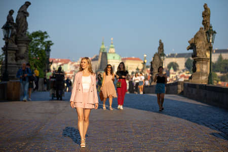 Prague, Czech republic - 20.09.2019: Young blonde woman walks along the Charles Bridge in Prague in sunny dayのeditorial素材