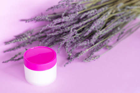 Lavender white body cream and lavender bouquet on violet backgroundの写真素材