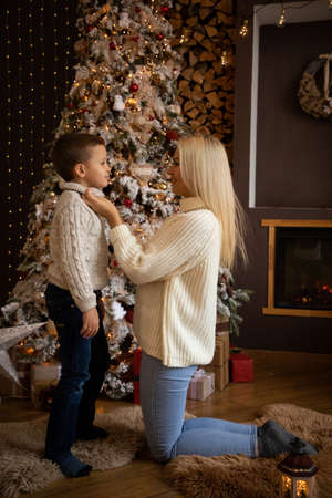 Mother and son are enjoying near christmas tree in modern decorated home, Happy New yearの写真素材