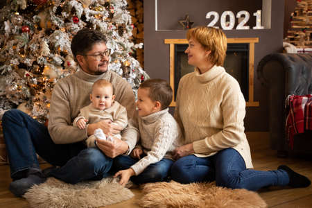 Family near Christmas tree in modern decorated home, Happy New year 2021の写真素材