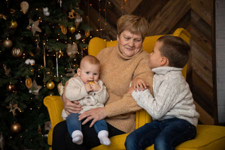 Grandmother with grandchildren near Christmas tree at decorated home, Happy New year 2021